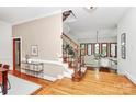 Open-concept foyer and living area with hardwood floors, staircase with wooden railing, and large windows at 4509 Rosecliff Dr, Charlotte, NC 28277