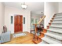 Inviting foyer featuring hardwood floors, a wooden front door with decorative glass, and a staircase leading to the upper level at 4509 Rosecliff Dr, Charlotte, NC 28277