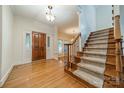 Welcoming foyer features hardwood floors, a wooden door, and a staircase with carpeted steps at 4509 Rosecliff Dr, Charlotte, NC 28277