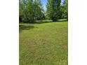 Expansive green lawn surrounded by lush trees, creating a serene outdoor space at 515 Benton St, Monroe, NC 28110