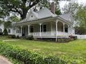 Charming home showcasing a wrap-around porch, lush greenery, and well-manicured lawn at 531 Walnut St, Statesville, NC 28677