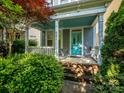 Inviting covered front porch with turquoise ceiling and front door, surrounded by manicured greenery at 541 Jetton St, Davidson, NC 28036