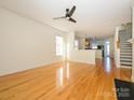 Spacious living room with hardwood floors, modern ceiling fan, and seamless transition to the kitchen at 541 Jetton St, Davidson, NC 28036