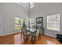 Bright dining area featuring tall ceilings, many windows, hardwood floors, and table with seating at 5621 Tipperlinn Way, Charlotte, NC 28278