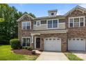 Charming townhome with stone accents, attached garages, manicured lawn, and inviting front entrance at 5621 Tipperlinn Way, Charlotte, NC 28278