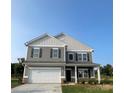 Beautiful two-story home with gray siding, white trim, a two-car garage, and inviting front porch at 6308 Honor Ave, Midland, NC 28107