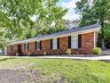 Brick home exterior featuring a manicured lawn and mature trees at 70 Cumberland Sw Ct, Concord, NC 28025