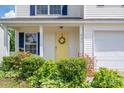 Close-up of house number above yellow door with decorative wreath and manicured shrubs at 937 Anchor Ne Way, Kannapolis, NC 28083