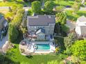 Aerial view of a brick home featuring a pool, deck, and solar panels at 9433 Stonebridge Way, Mint Hill, NC 28227