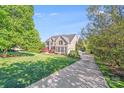 Charming brick home with mature trees and a long driveway on a sunny day at 9433 Stonebridge Way, Mint Hill, NC 28227