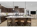 Modern kitchen features a large island with seating and pendant lighting, and dark wood cabinetry at 9527 Teamwork Nw St, Concord, NC 28027