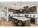 Open kitchen with stainless steel appliances, a central island, and dark wood cabinets offering ample storage at 9527 Teamwork Nw St, Concord, NC 28027