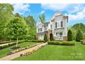 Charming two-story home boasts lush landscaping and a walkway lined with colorful flowers at 9596 Pacing Nw Ln, Concord, NC 28027