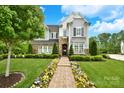 Beautiful two-story home with stone accents, manicured lawn, and a colorful flower-lined walkway at 9596 Pacing Nw Ln, Concord, NC 28027