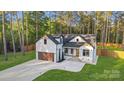 Attractive home with white exterior, black trim, and inviting entryway with stone steps and stylish details at 10125 Bethel Church Rd, Midland, NC 28107
