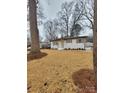 Charming one-story home with white brick, light blue door, and a well-manicured lawn at 106 Greentree Dr, Mount Holly, NC 28120
