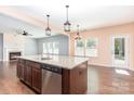 Granite kitchen island with sink, dishwasher, wood cabinets, and pendant lighting at 1071 Bassett Way, Fort Mill, SC 29707