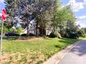A picturesque home with mature trees and landscaping is partially obscured by a stop sign in the foreground at 10804 Back Ridge Rd, Charlotte, NC 28277