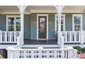 Close-up of the front door and porch with seating and visible house number for easy identification at 10822 Brandie Meadow Ln, Huntersville, NC 28078