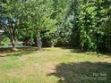 Lush backyard surrounded by mature trees and green lawn at 1109 Reid Harkey Rd, Matthews, NC 28105