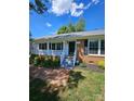 Charming brick home featuring a welcoming front porch and beautifully landscaped front yard on a sunny day at 1109 Reid Harkey Rd, Matthews, NC 28105