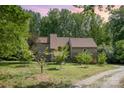 Exterior view of home with mature trees, large front yard, and gravel driveway at 1160 Walton Pl, Salisbury, NC 28146