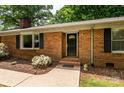 Close up of front door on brick home with black shutters and tidy landscaping at 13030 Mayes Rd, Huntersville, NC 28078