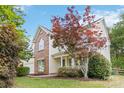 Charming two-story home with front porch and well-manicured yard with various trees at 1308 Pennington Nw Pl, Concord, NC 28027