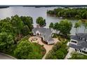An aerial view of a luxury waterfront home with mature trees and a private dock on the lake at 140 Lightship Dr, Mooresville, NC 28117