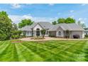 Beautiful front yard with circular driveway, lush lawn, and elegant landscaping at 140 Lightship Dr, Mooresville, NC 28117