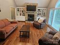 Bright living room with a stone fireplace, built-in shelves, and large windows at 16134 Tinura Ct # 134, Tega Cay, SC 29708