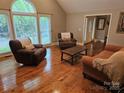 Well-lit living room with hardwood floors and large windows with outside view at 16134 Tinura Ct # 134, Tega Cay, SC 29708
