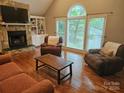 Open living room features a stone fireplace, built-in shelves, and large windows at 16134 Tinura Ct # 134, Tega Cay, SC 29708