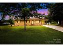 Charming brick home with a well-manicured lawn and mature trees creating a picturesque setting at 1811 Belmar Dr, Gastonia, NC 28052