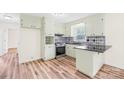 Well-lit kitchen with updated appliances, stylish backsplash, and durable hard wood flooring at 1811 Belmar Dr, Gastonia, NC 28052
