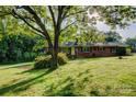 Well-maintained brick home featuring a lush, green lawn and mature trees providing shade at 211 Amos Homesley Rd, Cherryville, NC 28021