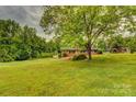 Ranch-style brick home with a sprawling green lawn and mature trees at 211 Amos Homesley Rd, Cherryville, NC 28021