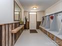 Mudroom with wood-paneled walls, built-in storage cubbies and an exterior door at 2125 Belle Vernon Ave, Charlotte, NC 28210