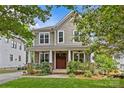 Inviting two-story home with a well-maintained yard, classic design, and a covered front porch with charming details at 2617 Bay St, Charlotte, NC 28205