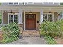 Close up of a charming front porch with stone accents, white columns, and a beautifully crafted wooden front door at 2617 Bay St, Charlotte, NC 28205