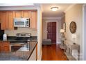 Modern kitchen with stainless steel appliances and granite countertops is adjacent to the front entry hall at 300 W 5Th St # 404, Charlotte, NC 28202