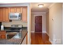 Open kitchen area with granite counters, stainless appliances, and hardwood floors near the entry at 300 W 5Th St # 404, Charlotte, NC 28202