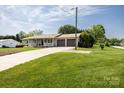 Ranch home with an attached two-car garage, wide driveway, and lush, manicured lawn at 3310 46Th Ne Ave, Hickory, NC 28601