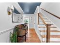 Inviting foyer featuring hardwood floors, stylish bench, staircase, and blue painted ceiling at 3424 Clydesdale Dr, Gastonia, NC 28056