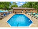 Sparkling in-ground pool surrounded by lounge chairs, umbrellas, and patio furniture for outdoor relaxation at 366 Faith Rd, Mooresville, NC 28115