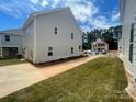 Exterior side view of a two-story home with a concrete driveway and manicured lawn at 4017 Grommet Ct, Matthews, NC 28105
