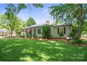 Quaint home exterior featuring a well-manicured lawn, mature trees and a charming porch swing adding to the curb appeal at 404 N Laurel St, Lincolnton, NC 28092