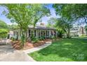 A picturesque home exterior featuring a well-manicured lawn, walkway, and lush landscaping with an inviting covered porch at 404 N Laurel St, Lincolnton, NC 28092