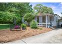 A charming side yard featuring a quaint bench, lush greenery, and a cozy, inviting atmosphere with natural landscaping at 404 N Laurel St, Lincolnton, NC 28092
