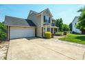 View of the house with a well-maintained two-car garage and concrete driveway, with manicured lawn at 4301 Windjammer Sw Ct, Concord, NC 28027
